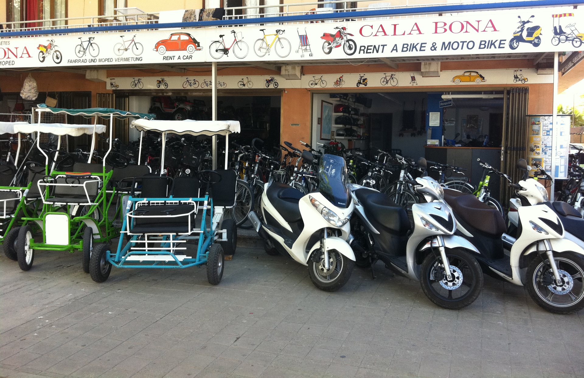 Fachada de Sancho Bikes en Cala Bona con bicicletas, motos y scooters de alquiler